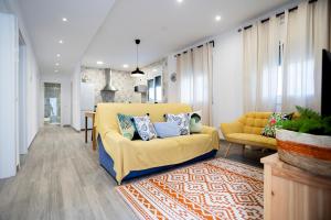 un soggiorno con un divano giallo e un tavolo di La caseta de cinta a El Lligallo del Gànguil