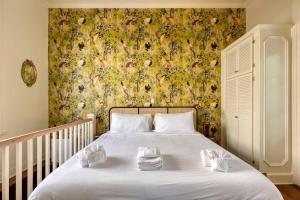 a bedroom with a white bed with a floral wallpaper at The Ashley Speakeasy King Suite includes breakfast in Charleston +16 photos