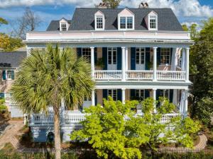 a white house with a palm tree in front of it at The Ashley Speakeasy King Suite includes breakfast in Charleston