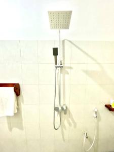 a shower with a shower head in a bathroom at Samsara Beach House in Kiganga +42 photos
