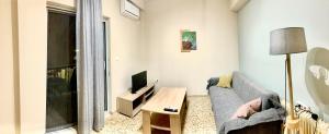 a living room with a couch and a tv at Rigas Apartment in Artemida