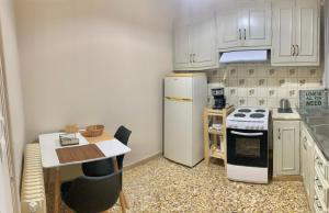 a kitchen with a white refrigerator and a table at Rigas Apartment in Artemida