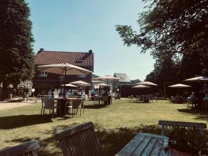 a group of people sitting at tables with umbrellas at Guesthouse 't Goed Leven in Stokrooie