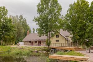 een huis met een brug naast een waterlichaam bij Veskivee Külalistemaja in Umbusi