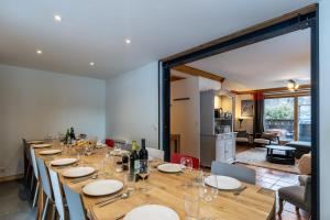 a long wooden table with chairs and wine glasses at Chalet Matterhorn in Mussillon +23 photos