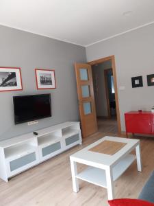 a living room with a tv and a white coffee table at Apartamento Salgueiro ORTIGUEIRA in Santa Marta de Ortigueira
