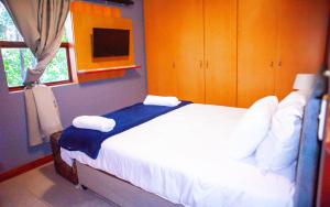 a bedroom with a bed with white sheets and pillows at Saint's Inn in Parklands +9 photos