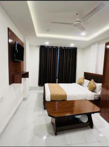 a bedroom with a bed and a television in it at Hotel Shiv in Indore