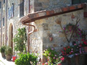 Hotel La Pradera de Marta في Quintanaentello: مبنى حجري عليه زهور ونباتات