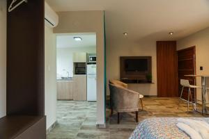 a bedroom with a bed and a living room with a kitchen at Apart de Sierras in Nono