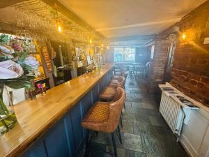 a bar with a long wooden counter in a restaurant at Longs Hotel & Inn in Woburn