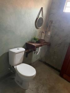 Un baño con un inodoro blanco y un espejo. en Beach House Tijuca, en Itarema