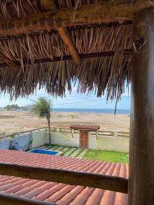 una cabaña de paja con vistas a la playa en Beach House Tijuca, en Itarema