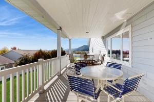 a white porch with a table and chairs on it at Sunnyside Retreat in Kalispell