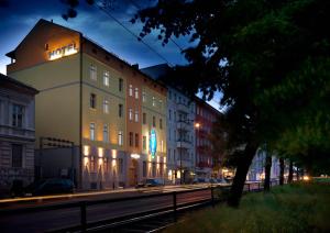 a building on the side of a street at night at Melarose Feng Shui Hotel in Berlin