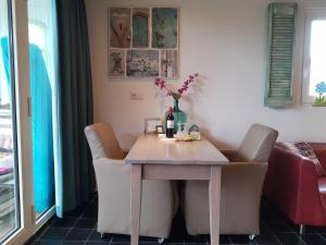a dining room table with chairs and a bottle of wine at DE ZEEBRIES Bed by the Sea in Westkapelle