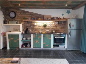 een keuken met groene kasten en een stenen muur bij DE ZEEBRIES Bed by the Sea in Westkapelle +11 foto's