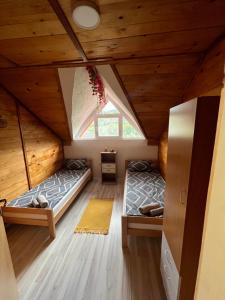 two beds in a room in a wooden house at Un Rio Sana in Gornji Ribnik