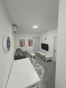 a living room with a couch and a tv at GK apartment Harmony in Bat Yam