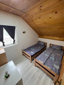 a room with two beds and a table in a cabin at Un Rio Sana in Gornji Ribnik
