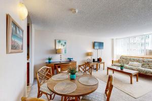 a living room with a table and a couch at Tradewinds Plaza 906 in Honolulu