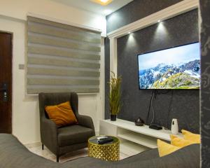 a living room with a tv and a chair at Aseda by Judisol Apartments in Kwedonu