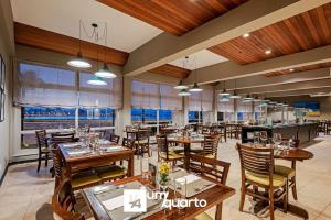 a restaurant with wooden tables and chairs and windows at Edifício Ponte Hercílio Luz in Florianópolis