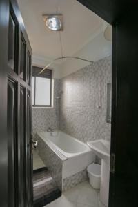 Un baño con bañera, inodoro y lavabo. en Suite 3, en Kampala