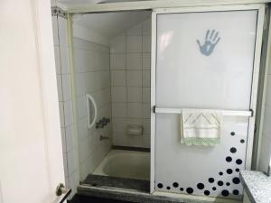 a shower with a hand on the door of a bathroom at Maui Hostel in Mar del Plata +19 photos