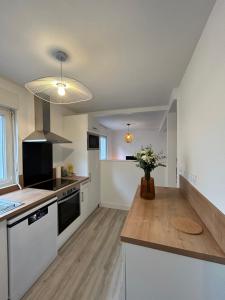 a kitchen with a counter top with a vase of flowers at Dans le petit bourg in Santec