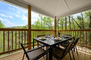 a table and chairs on a porch with a view at Lazy Bear in Sevierville