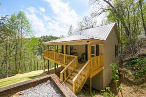 a small house with a porch and wooden stairs at Lazy Bear in Sevierville