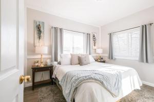 une chambre blanche avec un lit et deux fenêtres dans l'établissement Corvallis OSU 3 Bedroom Cheerful Bungalow House, à Corvallis