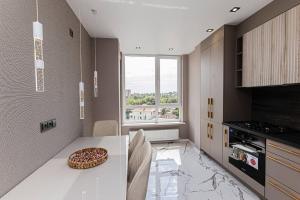 a kitchen with a table with a pizza on it at RentApart Center City in Chişinău