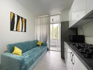 a living room with a blue couch in a kitchen at RentApart Center City in Chişinău