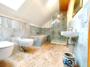 a bathroom with a sink and a toilet and a tub at Unik Villa Brunnen Blick mit offenem Dachstuhl in Sankt Andreasberg