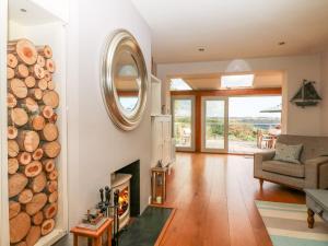 a living room with a fireplace and a mirror at Dove Cottage in Dittisham