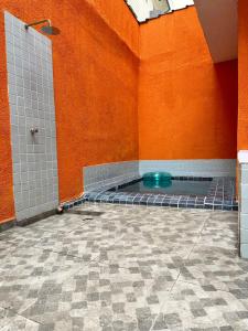 a bathroom with a blue tub in an orange wall at Casa com Piscina e Churrasqueira ótima localização in Praia Grande
