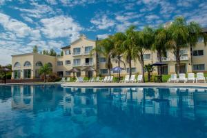 a pool at a resort with chairs and palm trees at Howard Johnson Pilar Resort Spa & Convention Center in Pilar
