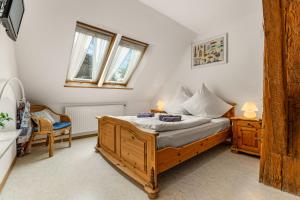 a bedroom with a wooden bed and two windows at Ferienwohnung Nordlicht in Greetsiel