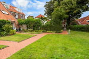 a yard with a brick walkway in front of a house at Ferienwohnung Nordlicht in Greetsiel