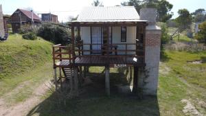 a small house with a deck on a hill at Bahía in Punta Del Diablo
