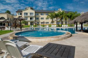 ein Swimmingpool mit Stühlen und einem Gebäude in der Unterkunft Howard Johnson Pilar Resort Spa & Convention Center in Pilar + 29 Fotos