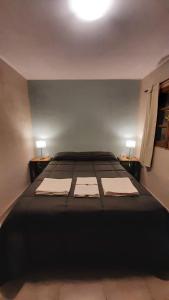 a bedroom with a large bed with two lamps on two tables at Hostal El Museo in Humahuaca