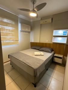 a bedroom with a bed and a ceiling fan at apartamento climatizado, 3 quartos c suíte garden in Cuiabá