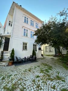 een wit huis met banken ervoor bij Ytre Markveien 37 in Bergen