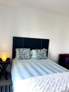 a bedroom with a bed with a blue headboard and pillows at Musical Waves in St. Helena Bay
