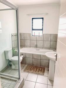 a bathroom with a tub and a toilet and a sink at Musical Waves in St. Helena Bay +58 photos