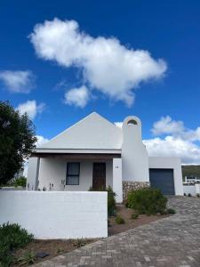 a white house with a fence in front of it at Musical Waves in St. Helena Bay