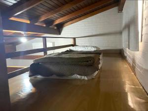 a bed in a room with a wooden floor at Pousada dos Pássaros in Gramado